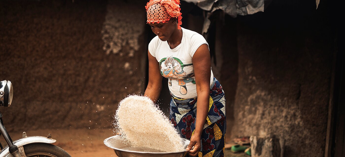Kakaobäuerin arbeitet mit Reis, den sie zur Diversifizierung anbaut. 